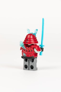 Yekaterinburg 'da. - Rusya. 04.08.2021. Zırhlı bir kılıç ve beyaz bir arka planda lego ninjalarından bir kask taşıyan kahraman buz savaşçısı. Yakın plan. seçici odak