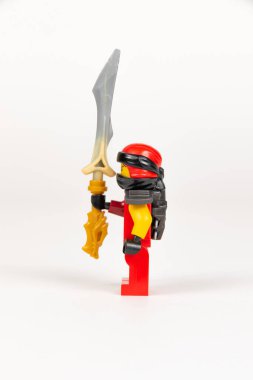 Yekaterinburg 'da. - Rusya. 04.08.2021. Beyaz arka planda lego ninjalarının kılıcıyla kırmızı kimonolu oyuncak kahraman Kai. Yakın plan. seçici odak