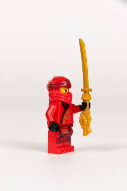 Yekaterinburg 'da. - Rusya. 04.08.2021. Beyaz arka planda lego ninjalarının kılıcıyla kırmızı kimonolu oyuncak kahraman Kai. Yakın plan. seçici odak