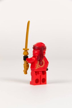 Yekaterinburg 'da. - Rusya. 04.08.2021. Beyaz arka planda lego ninjalarının kılıcıyla kırmızı kimonolu oyuncak kahraman Kai. Yakın plan. seçici odak