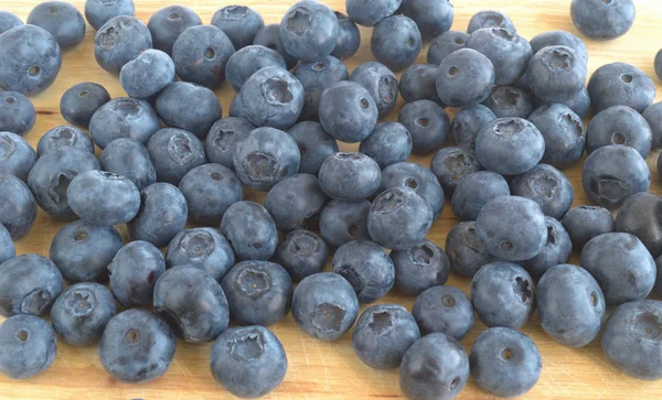 The berries of blueberry scattered on a cutting board — Stock Photo, Image