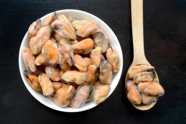 Donmuş, soyulmuş midyeler, kabuksuz, yuvarlak bir salata yayında