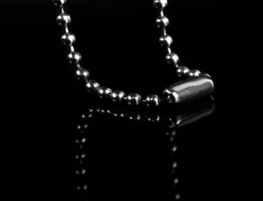 Bir anahtarlık için zincir, siyah bir arkaplanda, yansımayla izole edilmiş.