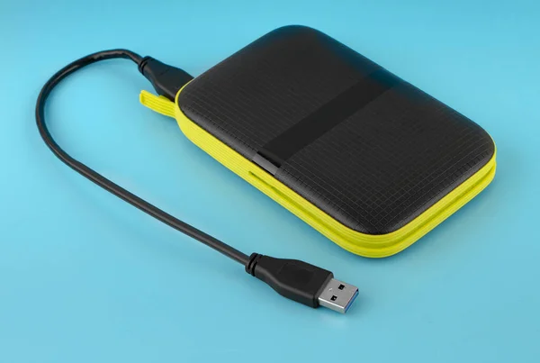 external hard drive, external drive with USB cable on a blue background