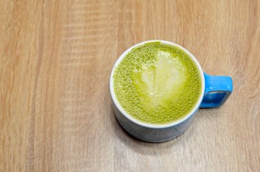 Yeşil köpüklü mavi kupa kibrit çayı