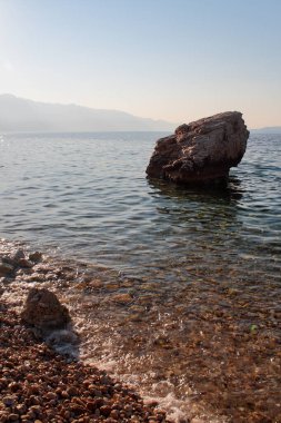 Hırvatistan 'da bir yaz günü, deniz kıyısındaki suda bir taş.