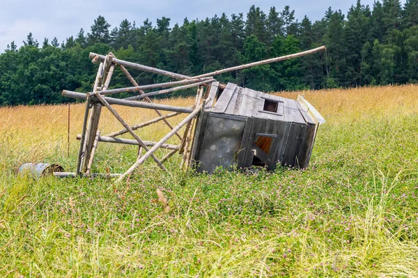 Hunting blind fallen to the ground, a wooden structure of a Hunting blind lying in a field
