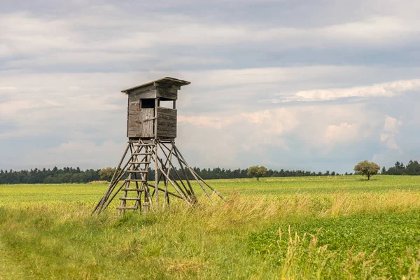 hunting blind on a field, in the background the sky with white clouds