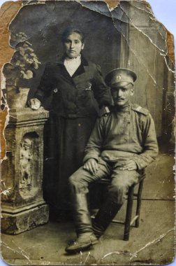 20. yüzyılın başlarından kalma antika siyah beyaz fotoğraf. Eski askeri üniformalı bir asker ve yakın plan bir kadını gösteriyor..