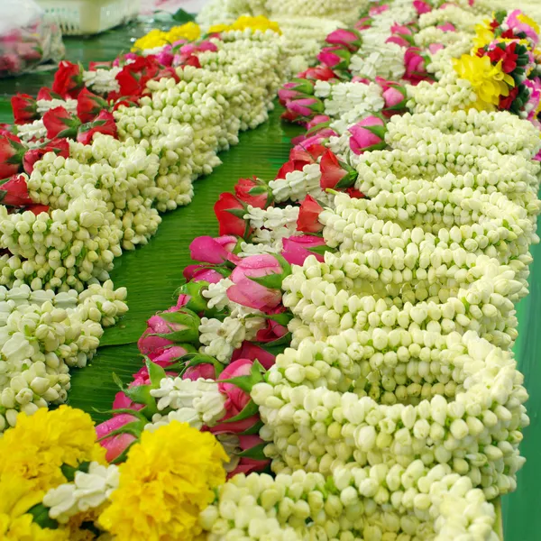 Guirnalda de jazmín con rosa y rosa roja sobre hoja de plátano —  Fotos de Stock