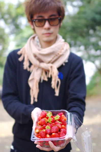 A man carry fresh red strawberry in box — Stock Photo, Image