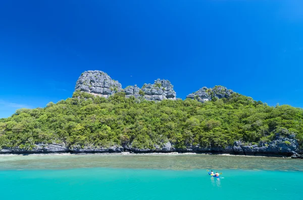 Two traveler are padding a kayak to the island on blue sky — Stock Photo, Image