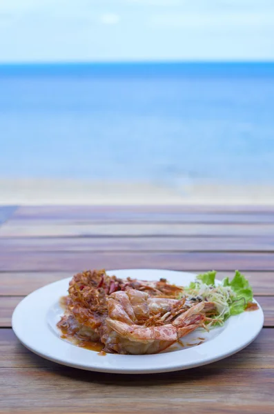 Plaka beach backgro ile demirhindi soslu kızarmış karides — Stok fotoğraf