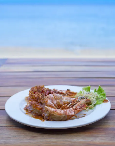 A sült garnélarák tamarind mártással a lemez beach backgro — Stock Fotó