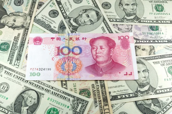 Chinese CNY yuan on many dollars background — Stock Photo, Image