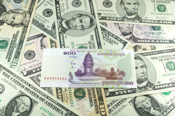 Cien Riel camboyano (KHR) en muchos dólares de fondo —  Fotos de Stock