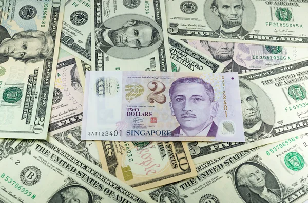 Twee dollar singapore op vele dollar achtergrond — Stockfoto