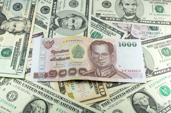 One thousand thai baht (THB) on many dollars background — Stock Photo, Image