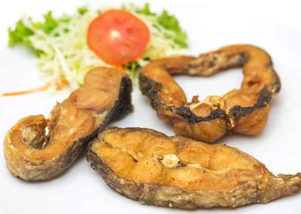 Филе жареной рыбы с овощами на тарелке — стоковое фото