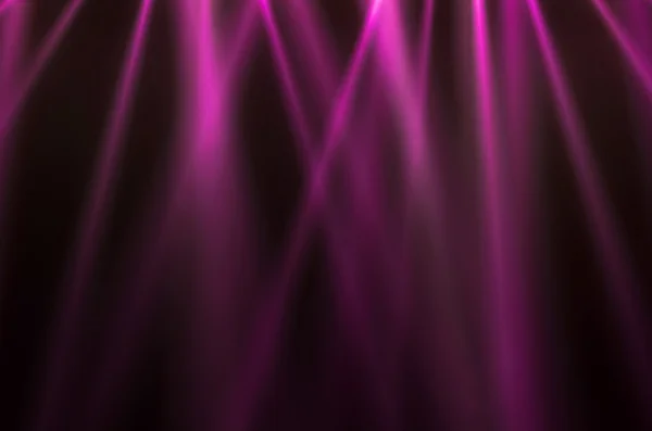 Roze lichtgevende stralen op een donkere achtergrond — Stockfoto