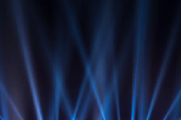 Blauwe lichtgevende stralen op een donkere achtergrond — Stockfoto