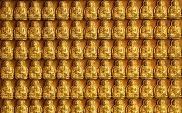 Ten thousand golden buddhas lined up along the wall of chinese t — Stock Photo, Image