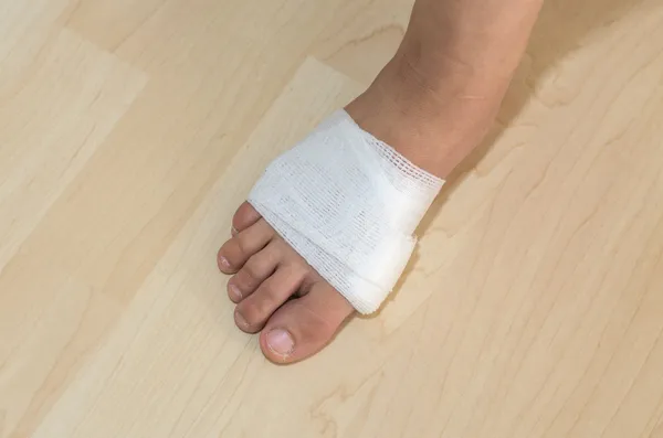 Vendaje de medicina blanca en el pie lesionado — Foto de Stock