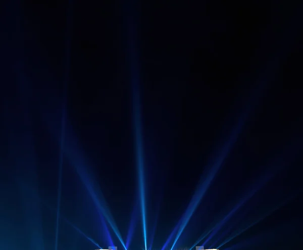 Modré světelné paprsky na tmavém pozadí — Stock fotografie