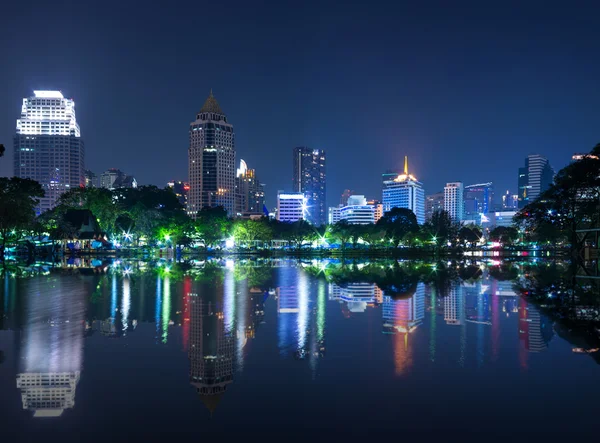Városkép tükrözik a tóra, a parkban, szürkületi időben. — Stock Fotó