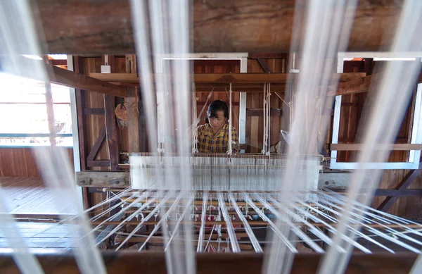 INLE, MYANMAR - DEC 31 : Unidentified woman was weaving silk fabric by method and machine traditional on December 31, 2010, Inle, Myanmar. Inle is famous for the tourism — Stock Photo, Image