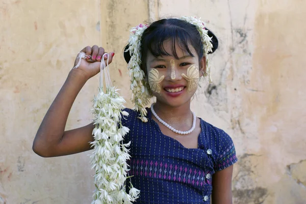 MANDALAY, MIANMAR - JANEIRO 03: Menina birmanesa sorridente não identificada com o tradicional thanaka em seu rosto em 03 de janeiro de 2011 em Mandalay, Mianmar . — Fotografia de Stock