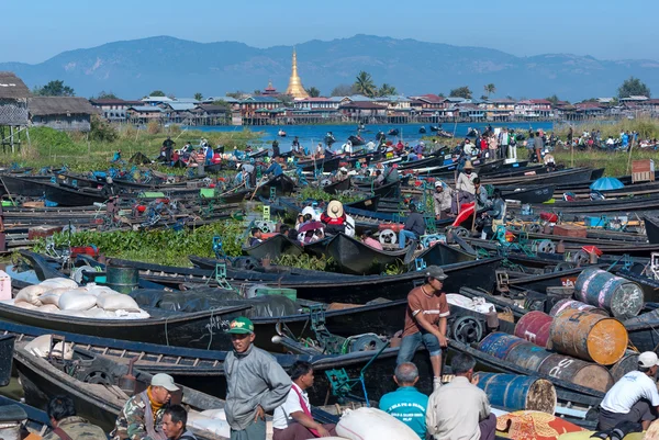 INLE, MYANMAR - DEC 31: O mercado local está lotado com barcos de linha de turistas e birmaneses no centro do famoso lago que têm pagode e fundo de montanha em 31 de dezembro de 2010 em Inle, Mianmar . — Fotografia de Stock