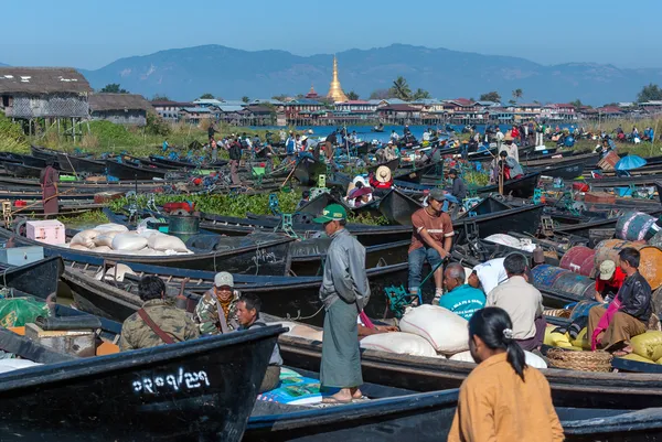 INLE, MYANMAR - DEC 31: O mercado local está lotado com barcos de linha de turistas e birmaneses no centro do famoso lago que têm pagode e fundo de montanha em 31 de dezembro de 2010 em Inle, Mianmar . — Fotografia de Stock