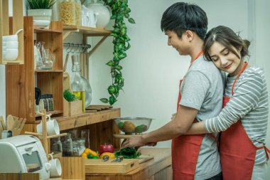 Mutlu Asya sevgilisi ya da sarılma ve mutluluk eylem içinde modern ev, çift ve yaşam tarzı konsept mutfak oda pişirme Çift.