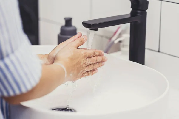 クローズアップアジアの女性が自宅の浴室で蛇口の水で手を洗う Covid 19パンデミックの医療 クリーニングと屈託のないコンセプト — ストック写真
