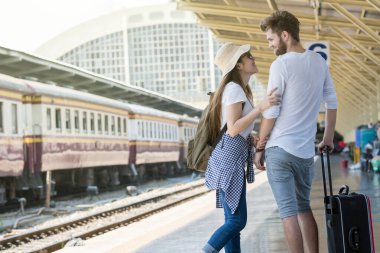 Bir çift çok ırklı gezgin birlikte tren istasyonuna, seyahat ve sevgili konseptine bakıyorlar.