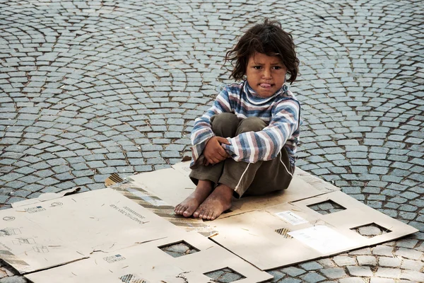 Unknown homeless kid sitting on the street Stock Photo