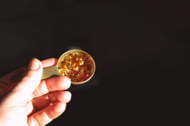 Kaşık içinde sarı fındıklı kapsüller. İlaçlar ve ilaçlar..