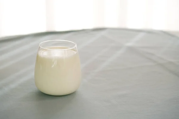 Vaso de leche sobre la mesa con fondo azul. —  Fotos de Stock
