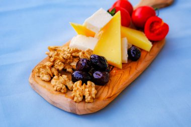 Balkondaki masada iki bardak kırmızı şarap ve peynir tabağı. Evde güzel yemekler..