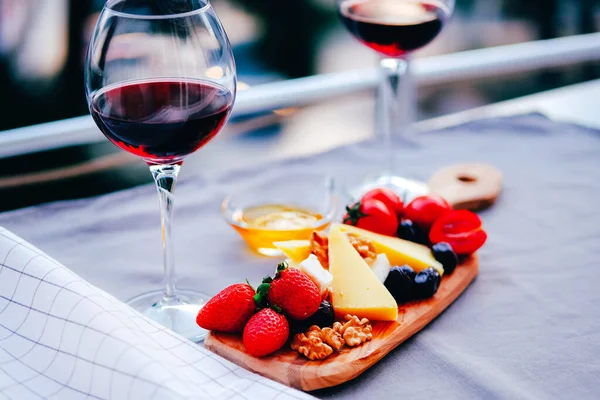 İki bardak şarap ve peynir tabağı. Aperetif.