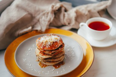 Akçaağaç pekmezli muzlu gözleme ve hindistan cevizli gevrek ve masada kahvaltı için çay.