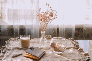 Bir fincan çay ya da bej renkli kahve ile bir masa. Kış sabahı.