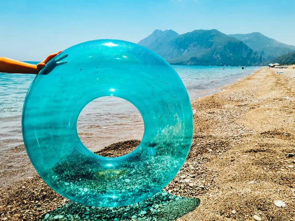 Blue inflatable swim ring float on the beach. Summer vocations concept.