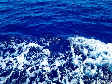 Turquoise surface of transparent sea water with sun glints. Summer vocations background.