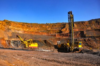 İki sondaj makinesi maden ocağında bir kuyu açıyor.