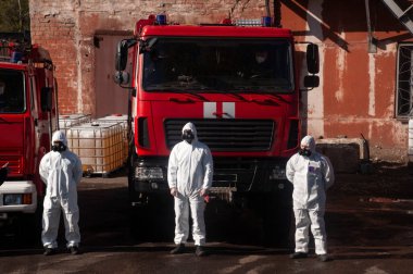 İtfaiyenin kurtarıcısı şehrin sokaklarını dezenfekte ediyor. Koronavirüse karşı önleyici yöntemler. Tehlikeli madde kıyafetleri uzmanı. Dezenfekte eden koronavirüs hücreleri salgını ve salgın hastalıkları temizliyor. 