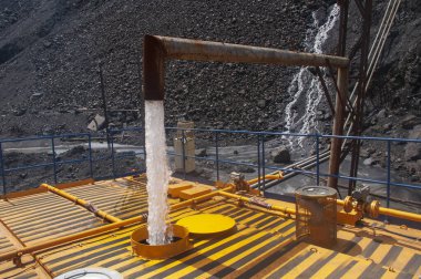 Sulama makinesi için su deposu dolduruluyor. Ağır kamyon yolu demir cevheri ocağına su döküyor. Toz temizleme, çevrenin korunması. Yolun tozdan sulanması