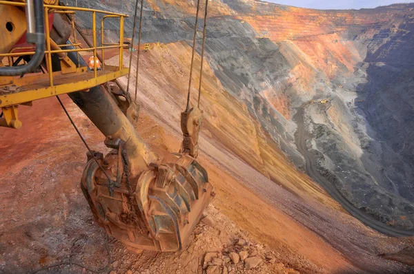 掘削機のバケツは鉄鉱石採石場の端にあります 採石パノラマ — ストック写真
