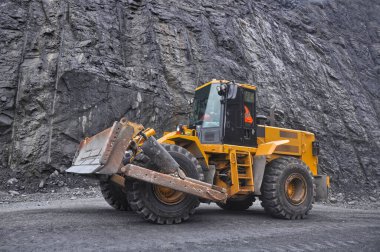 Tekerlekli buldozer demir madeninin yollarında ilerliyor.